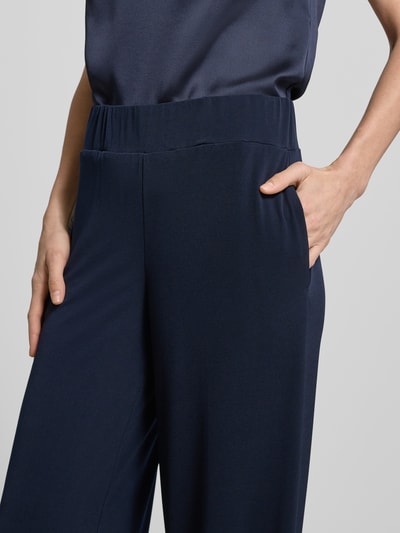 Frauenmodel trägt Stoffhose mit Gesäßleistentaschen und elastischem Bund von Vera Mont, dunkelblau, Material-Mix mit Stretch-Anteil, Loose-Fit, Nahaufnahme Oberkörper.
