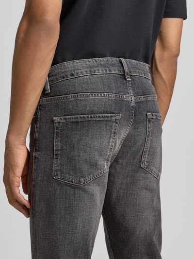 Männermodel trägt Slim Fit Jeans aus Stretch-Denim Modell 'DELAWARE' von BOSS in grauer Denim-Optik mit 5-Pocket-Design, Nahaufnahme Rückansicht.