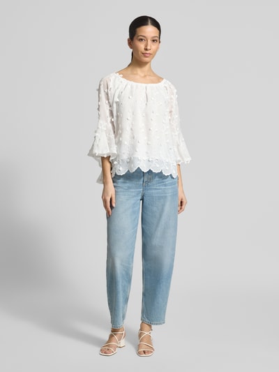 Kobiece modelka nosi Blusenshirt mit Spitze od Apricot, biały, luźny krój, dekolt Carmen, koronka, falbany, długość tyłu w rozmiarze S: 51 cm, długość rękawa w rozmiarze S: 42 cm, widok całej sylwetki z przodu.