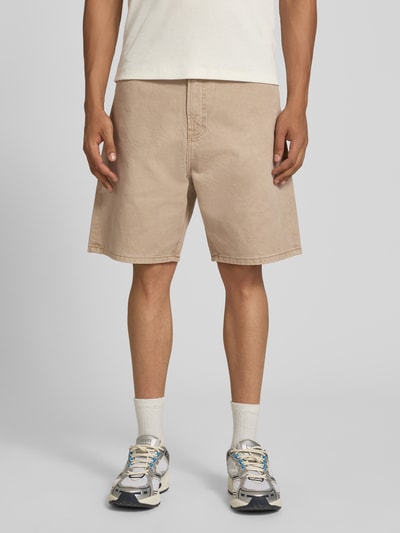 Männermodel trägt Bermudas im 5-Pocket-Design Modell 'TONY ORIGINAL' von Jack & Jones in Beige aus reiner Baumwolle, Straight Fit, Ganzkörperansicht von vorne. Bundweite bei Größe M: 42 cm, Innenbeinlänge: 20 cm, Knopf- und Reißverschluss.