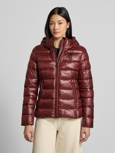 Frauenmodel trägt Jacke in Stepp-Optik Modell 'CAROLL' von Blauer USA in Bordeaux mit Kapuze, Zweiwege-Reißverschluss, Ganzkörperansicht von vorne.