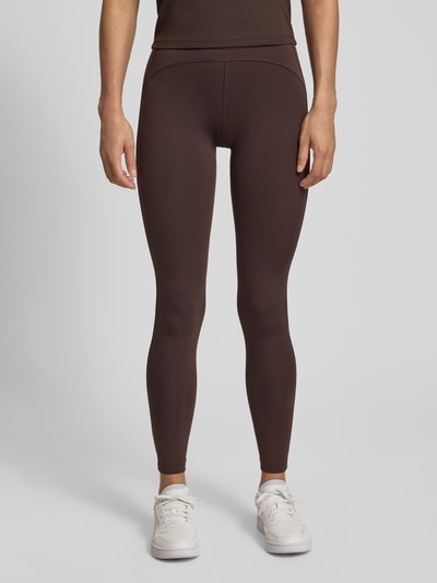 Frauenmodel trägt Regular Fit Leggings mit Label Print von adidas Sportswear, unifarben, High Waist, elastischer Bund, Ganzkörperansicht von vorne.