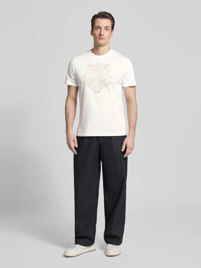 Męski model nosi T-shirt z okrągłym dekoltem od Antony Morato, mieszanka bawełny i elastanu, krój regular fit, motyw, długość tyłu w rozmiarze M: 69 cm, widok całej sylwetki z przodu.