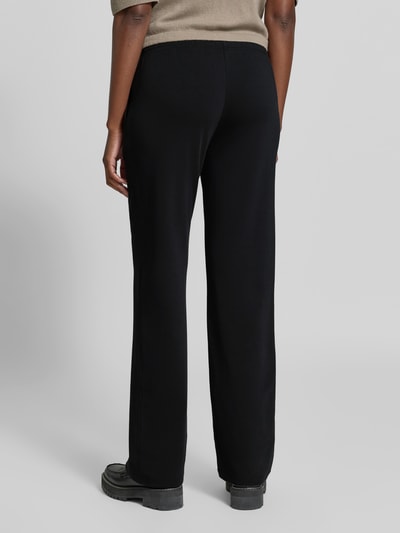 Frauenmodel trägt Flared Fit Sweatpants mit Tunnelzug von Juvia in Schwarz, elastischer Baumwoll-Modal-Mix, Bund und Taschen, Ganzkörperansicht Rückansicht.