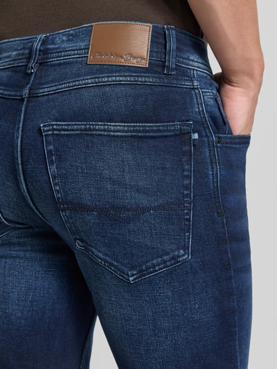 Männermodel trägt Comfort Fit Jeans mit Eingrifftaschen von Christian Berg Men, Baumwoll-Mix, dunkle Waschung, Detailaufnahme Rückansicht.