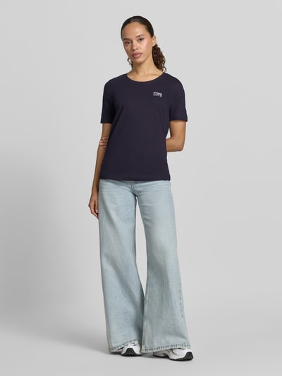Frauenmodel trägt T-Shirt mit Statement-Stitching und Rundhalsausschnitt von Christian Berg Woman, reine Baumwolle, dunkelblau, Ganzkörperansicht von vorne.