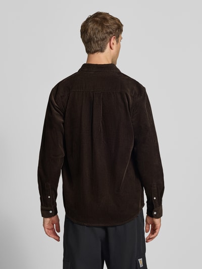 Männermodel trägt Regular Fit Freizeithemd mit Logo-Stitching Modell 'MADISON' von Carhartt Work In Progress in Dunkelbraun, Ganzkörperansicht Rückansicht. Reine Baumwolle, Button-Down-Kragen, Knopfleiste, Sportmanschetten, abgerundeter Saum, strukturierte Textur.