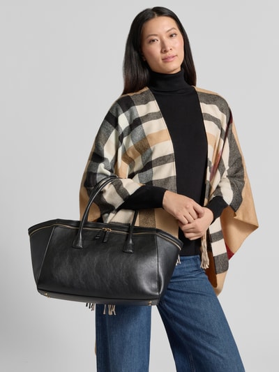 Frauenmodel trägt Citybag in Leder-Optik Modell 'Fiori' von MANGO, schwarze Tasche mit goldfarbenen Details, Ganzkörperansicht von vorne.