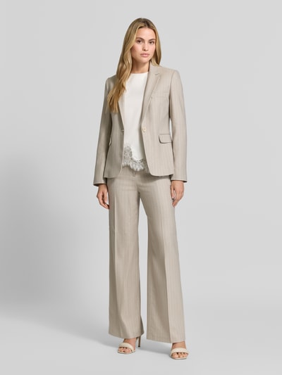 Frauenmodel trägt Wide Fit Hose mit Viskose-Anteil von Christian Berg Woman Selection in Beige mit Bügelfalten, Ganzkörperansicht von vorne.