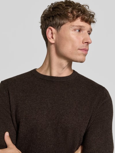 Männermodel trägt Kaschmirpullover mit gerippten Abschlüssen von Christian Berg Men in Dunkelbraun, feine Textur, Nahaufnahme Oberkörper. Reines Kaschmir, gerader Schnitt, Rundhalsausschnitt, Rückenlänge 72 cm, Ärmellänge 72 cm.