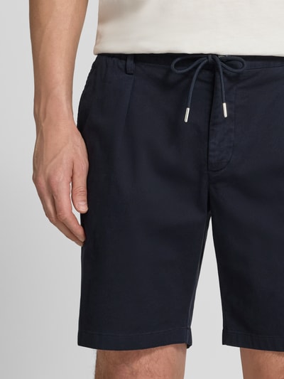 Männermodel trägt Straight Fit Shorts mit Bundfalten von Profuomo in Dunkelblau, elastischer Bund mit Tunnelzug, Nahaufnahme Oberkörper.
