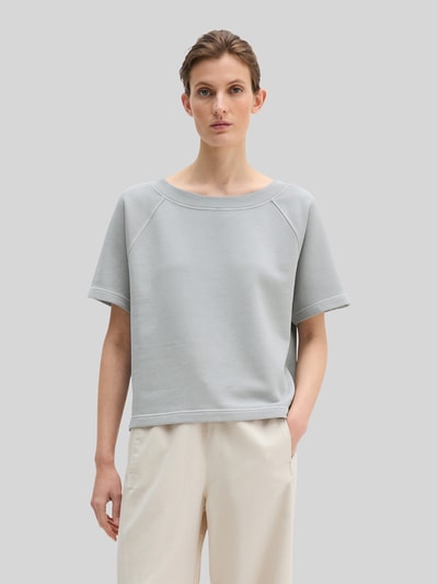 Frauenmodel trägt Regular Fit Sweatshirt aus reiner Baumwolle von Marc O'Polo, Optik: Unifarben, Label-Print, Rundhals, Kurzarm, Rumpfabschluss: Gerippt, Material: Reine Baumwolle, helle Farben, glatte Textur, Ganzkörperansicht von vorne.