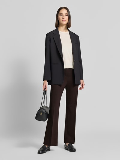 Frauenmodel trägt Schlaghose aus Viskose-Mix mit Bügelfalte von Rich & Royal, Dunkelbraun, Bootcut Fit, Ganzkörperansicht von vorne.