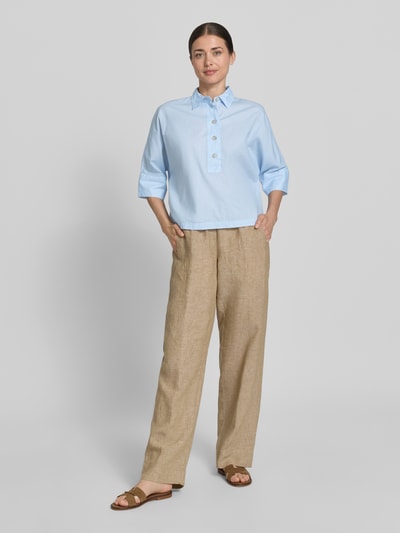 Frauenmodel trägt Boxy Fit Bluse mit 3/4-Arm von Emily Van den Bergh aus Reine Baumwolle, Hellblau, Hemdblusenkragen, Knopfleiste, Ganzkörperansicht von vorne.