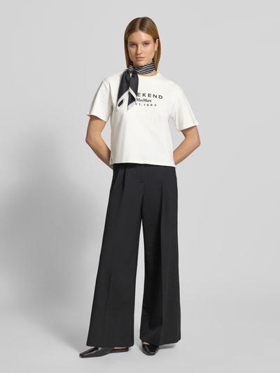 Kobiece model nosi damski t-shirt Regular Fit T-Shirt aus reiner Baumwolle Modell 'SABATO' od Weekend Max Mara, efekt: jednolity kolor, krój regular fit, wyhaftowana aplikacja kwiatowa, okrągły dekolt, krótki rękaw, wykończenie materiału: drobne prążkowanie, materiał: czysta bawełna; widok całej sylwetki z przodu.