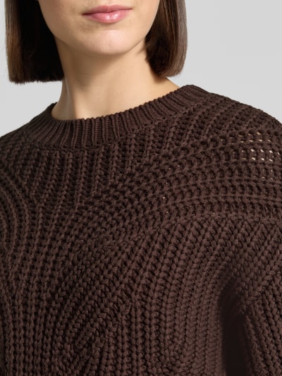 Frauenmodel trägt Relaxed Fit Strickpullover aus Baumwoll-Mix von Apricot, braun, grob gestrickt, Rundhalsausschnitt, Nahaufnahme Oberkörper. Rückenlänge Größe S 50 cm, Ärmellänge 53 cm, Damen Strickpullover, gerippte Abschlüsse.