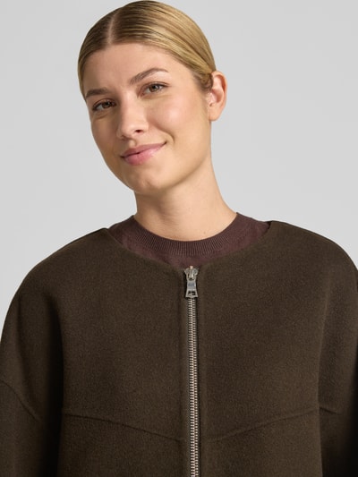 Frauenmodel trägt Doubleface Wolljacke mit abnehmbarer Steppkapuze von Blonde No. 8 in Braun, Wollmischung, Nahaufnahme Oberkörper.