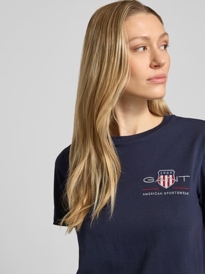 Frauenmodel trägt T-Shirt mit Rundhalsausschnitt und Label-Stitching von Gant aus Reine Baumwolle, Regular-Fit, Nahaufnahme Oberkörper.