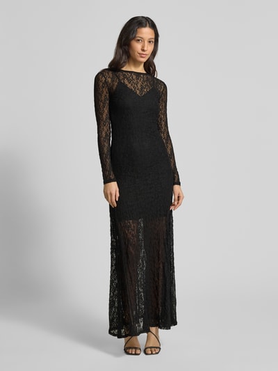 Vrouwenmodel draagt smal kanten jurk met onderjurk, model 'NULIETTA' van HUGO, effen, semi-transparante look, maxi lengte, ronde hals, kanten motief, logodetail, ritssluiting, lange mouw, detail: onderjurk, materiaalverwerking: kant. Ganzkörperansicht van voren.