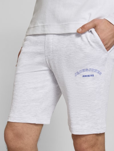 Männermodel trägt Shorts mit Logo-Print Modell 'GORDON' von Jack & Jones aus Baumwoll-Mix, Relaxed-Fit, Nahaufnahme Oberschenkel.