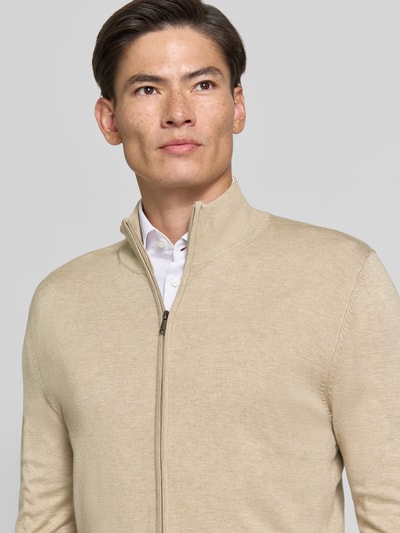 Männermodel trägt Slim Fit Strickjacke aus Mieszanka wiskozy mit Stójka, zamek błyskawiczny, wykończenia: elastyczne, MCNEAL, kolor beżowy, Ganzkörperansicht von vorne, Długość tyłu w rozmiarze M: 70 cm, Długość rękawów w rozmiarze M: 70 cm