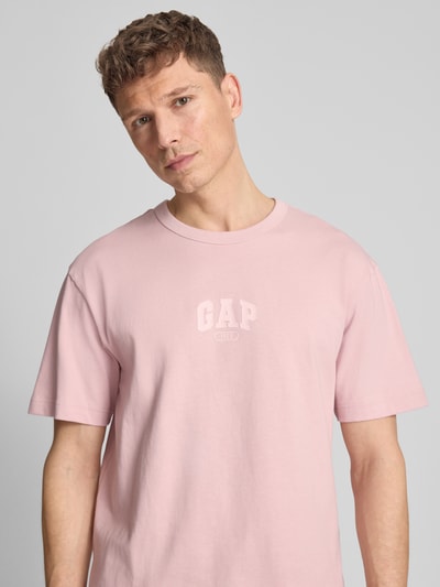 Męski model nosi T-Shirt mit Logo und Rundhalsausschnitt od GAP, bawełna, krój regular fit, logo, okrągły dekolt, długość tyłu 61 cm, Nahaufnahme oberkörper.