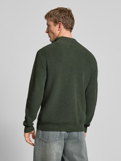 Männermodel trägt Strickpullover mit Stehkragen von Levi's®, dunkles Grün, lockerer Schnitt, gerippte Textur, Rückenansicht, Ganzkörperansicht.