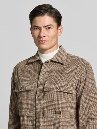 Männermodel trägt Regular Fit Hemdjacke im Allover-Look Modell 'OLIVER' von JACK & JONES aus reiner Baumwolle mit Kentkragen, Nahaufnahme Oberkörper.