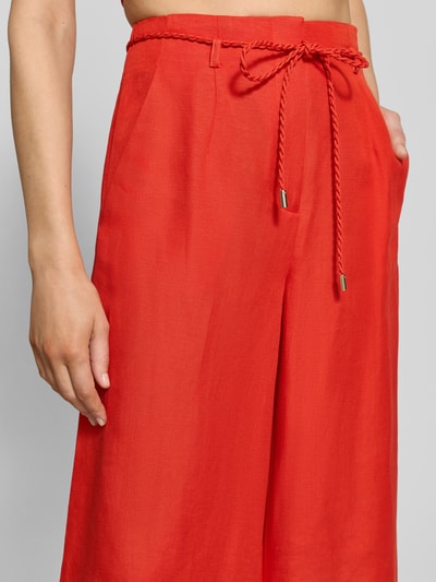 Frauenmodel trägt Wide Leg Hose aus Leinen-Viskose-Mix Modell 'Myla' von Forever New, leuchtend rot, mit Bindegürtel, Nahaufnahme Oberkörper.