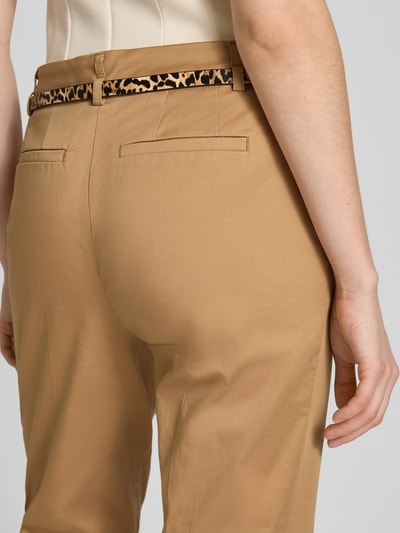 Kobiece modelka nosi Slim Fit Hose in verkürzter Passform mit Gürtel od Christian Berg Woman, bawełniany miks z dodatkiem wiskozy, krój slim fit, pasek, szerokość w rozmiarze 36: 39 cm, długość nogawki od wewnątrz w rozmiarze 36: 72 cm, detaliczne zbliżenie tylnej części.