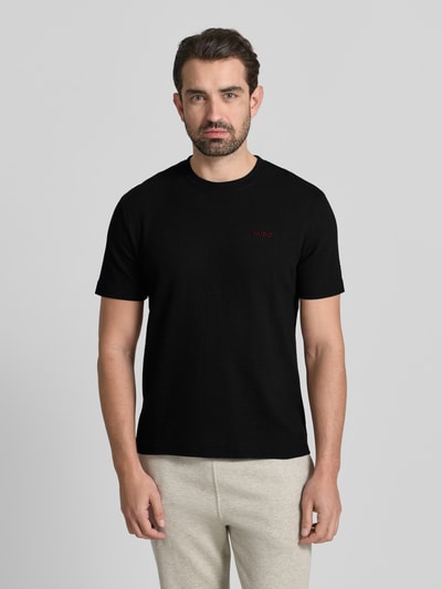 Mannelijk model draagt T-Shirt met Label-Stitching model 'Austin' van HUGO, zwart, katoenmix, regular fit, ronde hals, voorkant volledige lichaamsweergave.