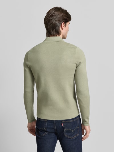 Männermodel trägt Slim Fit Pullover mit Polokragen Modell 'GUNA' von Samsøe Samsøe in hellem Grün, Rückenansicht, Ganzkörperansicht Rückansicht.