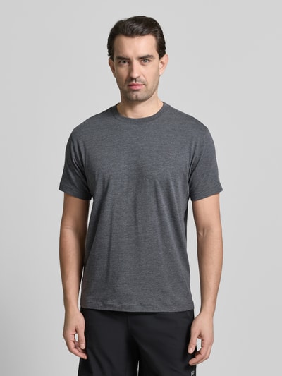 Männermodel trägt Regular Fit T-Shirt mit Rundhalsausschnitt von Fabletics in Dunkelgrau, elastischer Baumwoll-Mix, Ganzkörperansicht von vorne.