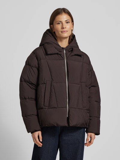 Frauenmodel trägt Steppjacke mit Kapuze und Reißverschluss von Smith and Soul in Dunkelbraun, Regular-Fit, Eingrifftaschen, Ganzkörperansicht von vorne, Rückenlänge 66 cm, Schulterbreite 42 cm, Brustweite 50 cm, Ärmellänge 68 cm.