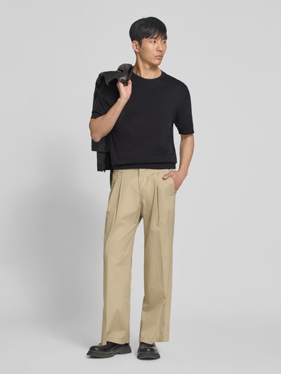 Männermodel trägt Stoffhose mit Biesen und Eingrifftaschen Modell 'LEEK' von Drykorn aus Reine Baumwolle, Wide-Fit, Ganzkörperansicht von vorne.