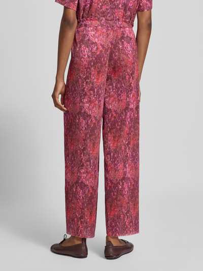 Frauenmodel trägt Wide Fit Hose in Falten-Optik von Rich & Royal mit floralem Allover-Print, elastischem Bund, Ganzkörperansicht Rückansicht.