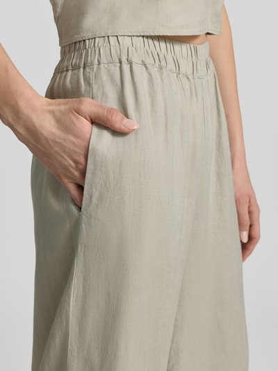 Frauenmodel trägt Leinenhose mit elastischem Bund von Style Icon Collection, beigefarbener Stoff mit strukturierter Oberfläche, Nahaufnahme Oberkörper.