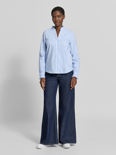 Vrouwenmodel draagt Regular Fit Bluse mit V-Ausschnitt van MORE in lichtblauw en wit katoenmix met stretch, all-over look, knoopsluiting, ruglengte maat 36: 64 cm, mouwlengte maat 36: 63 cm, voorkant volledig zichtbaar, Ganzkörperansicht van voren.