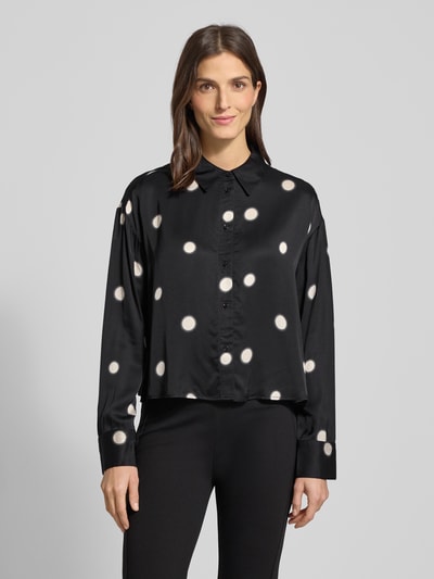 Vrouwenmodel draagt Overhemdblouse met knoopsluiting Model 'Famena' van Opus in zwart met witte stippen, zuivere viscose, los model, overhemddkraag, ruglengte 56 cm, mouwlengte 56 cm, Ganzkörperaanzicht van voren.