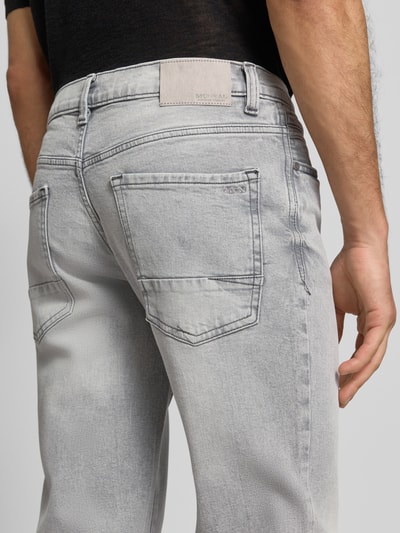 Männermodel trägt Regular Fit Jeans im Used-Look von MCNEAL, Baumwoll-Elasthan-Mix, graue Waschung, Detailaufnahme Rückansicht