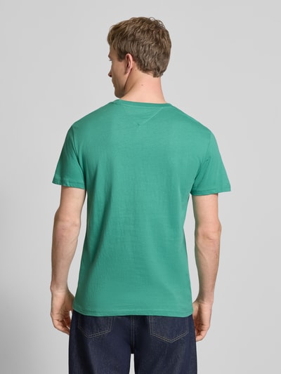 Männermodel trägt Slim Fit T-Shirt aus reiner Baumwolle Modell 'LINEAR CHEST TEE' von Tommy Jeans, Optik: Unifarben, Regular-Fit, Rundhals, Kurzarm, Material: reine Baumwolle, Ganzkörperansicht Rückansicht.
