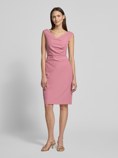 Modelka nosi Knielanges Cocktailkleid mit Raffungen von Vera Mont, różowy materiał z domieszką stretchu, prosty krój, długość do kolan, dekolt w serek, szerokość w rozmiarze 36: 42 cm, długość pleców w rozmiarze 36: 99 cm, widok całej sylwetki z przodu.