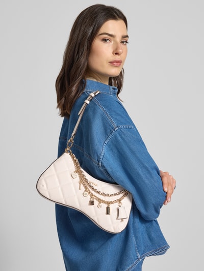 Frauenmodel trägt Shoulder Bag mit Logo-Detail Modell 'Libby' von Guess in Leder-Optik mit Zier-Detail, Hauptfach mit Reißverschluss, abnehmbarem Schulterriemen, cremefarben, Struktur mit Kettenapplikation, Breite 30 cm, Länge 16 cm, Tiefe 5 cm, Länge Schulterriemen 55 cm, Ganzkörperansicht von vorne.
