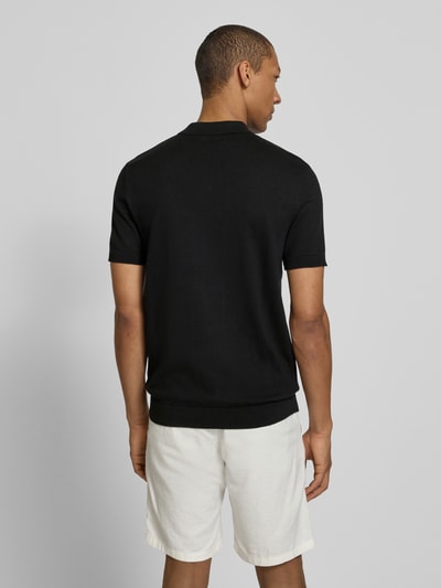 Männermodel trägt schwarzes Regular Fit Poloshirt aus reiner Baumwolle Modell 'BERG' von SELECTED HOMME, unifarben, Rückansicht.