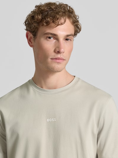 Männermodel trägt Regular Fit T-Shirt aus Baumwoll-Mix Modell 'TCHUP' von BOSS Orange, Optik: Unifarben, Label-Schriftzug, Nahaufnahme Oberkörper.
