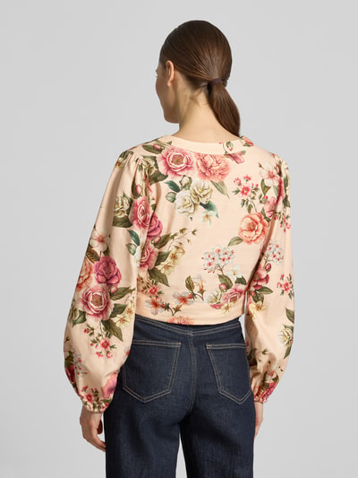 Frauenmodel trägt Cropped Bluse aus Leinen-Viskose-Mix Modell 'SHIRLEY' von Guess mit Blumenmuster, Rückenlänge 42 cm, Ganzkörperansicht Rückansicht.