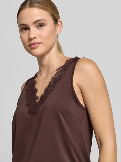 Frauenmodel trägt Regular Fit Bluse mit Spitzenbesatz Modell 'Bicco' von FREE/QUENT in Braun, V-Ausschnitt, ärmellos, Nahaufnahme Oberkörper.