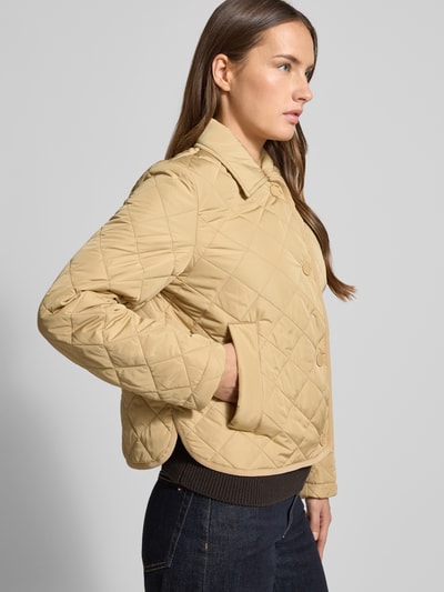 Vrouwenmodel draagt Regular Fit Steppjacke met Umlegekragen Modell 'GELO' van Weekend Max Mara in effen beige met ruitpatroon, zijzakken, lange mouwen, label stitching en patch, allover binnenvoering; zijaanzicht, halflichaam.