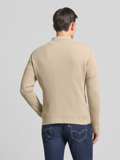 Męski model nosi Kardigan rozpinany z fakturowanym wzorem Model 'Yuris' od Cinque, mieszanka bawełny, krój slim fit, kolor beżowy, kołnierzyk polo, listwa guzikowa, długość tyłu 70 cm, długość rękawa 67 cm, widok całej sylwetki z tyłu.
