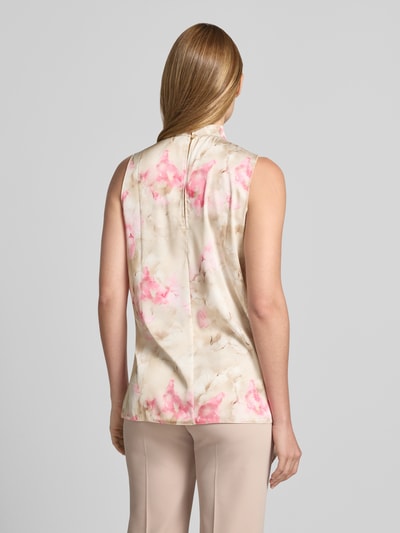 Männermodel trägt Bluse mit Stehkragen und asymmetrischem Design von Rinascimento, kremowe i różowe odcienie, materiał z domieszką stretchu, prosty krój, marszczenia, wycięcie z tyłu, długość tyłu w rozmiarze S: 67 cm, Ganzkörperansicht Rückansicht.